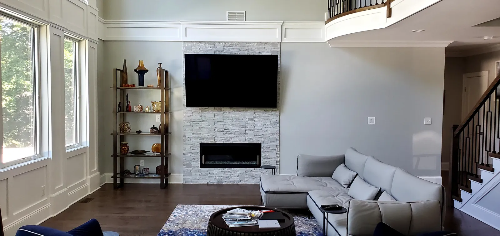 Wall-mounted TV on a stone fireplace with hidden wiring in a living room